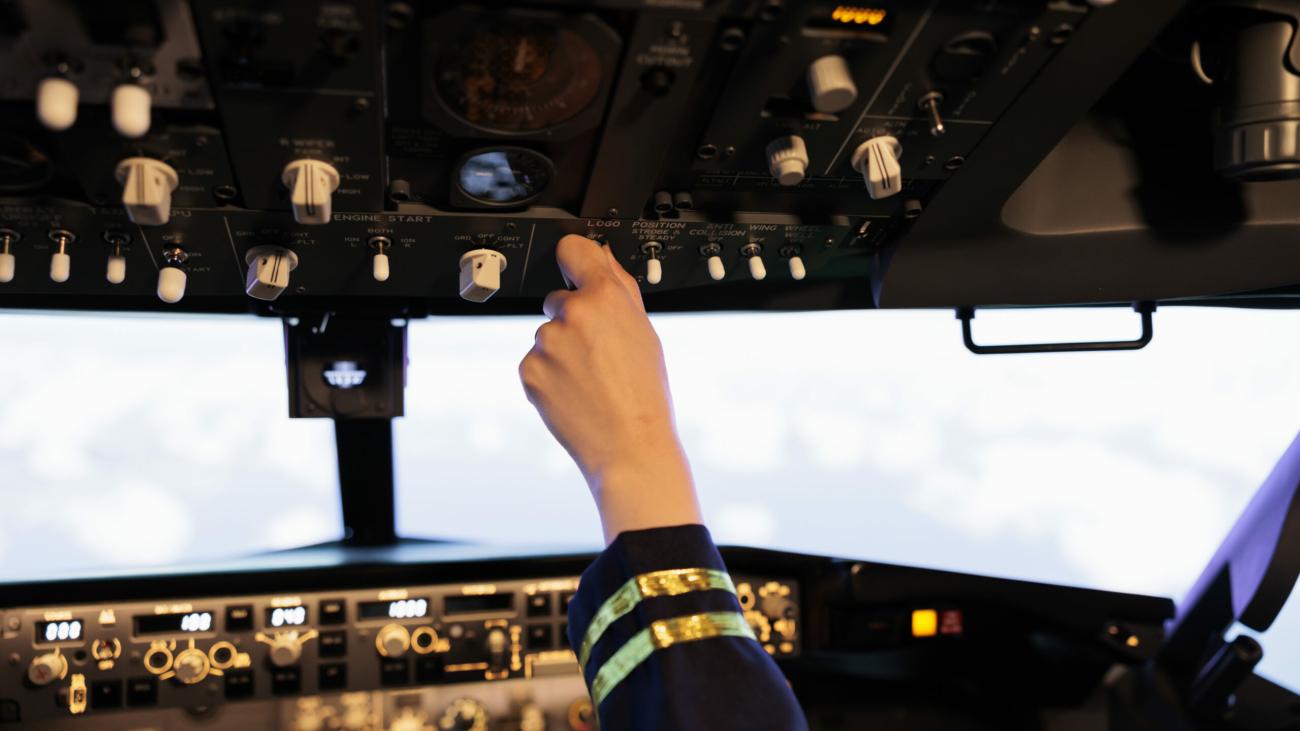 Female copilot pushing buttons and switch on dashboard panel, flying airplane with navigation and control command. Using power engine lever and radar compass to takeoff with plane. Close up.