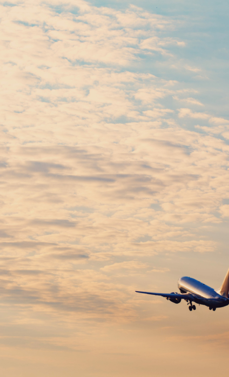 Airplane taking off at the sunset sky, silhouette of aircraft in the sky
